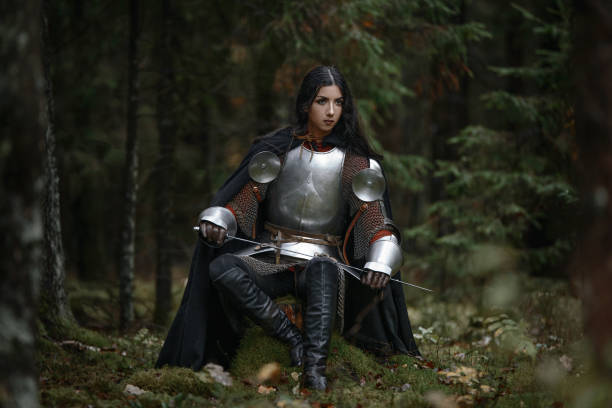 istock A beautiful warrior girl with a sword wearing chainmail and armor in a mysterious forest. 868449898