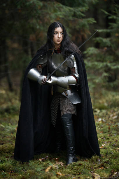 istock A beautiful warrior girl with a sword wearing chainmail and armor in a mysterious forest. 868450098