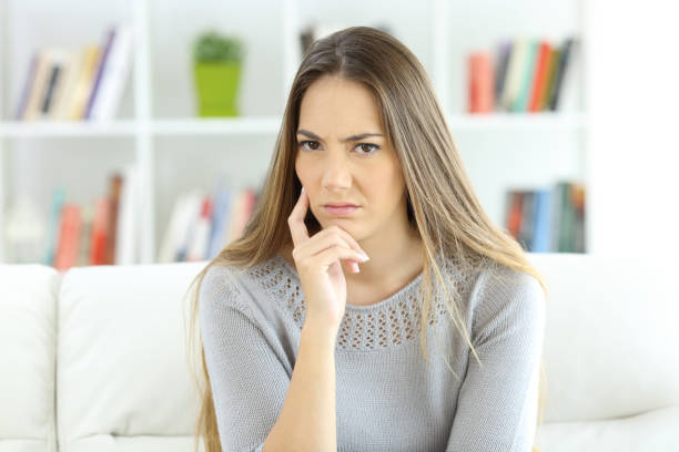 istock Suspicious woman looking at camera at home 868450116
