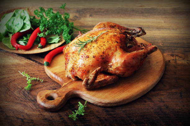 istock Whole roasted chicken on cutting board. Wooden rustic background 868450842