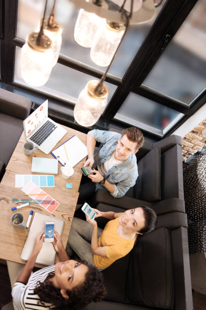 istock Smiling man and women using their phones while working 868451072