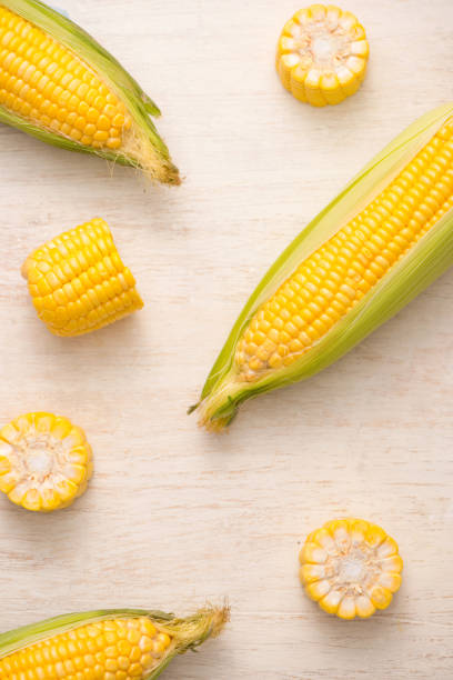 istock Sweet corns. Fresh corn on cobs on wooden table. 868451400
