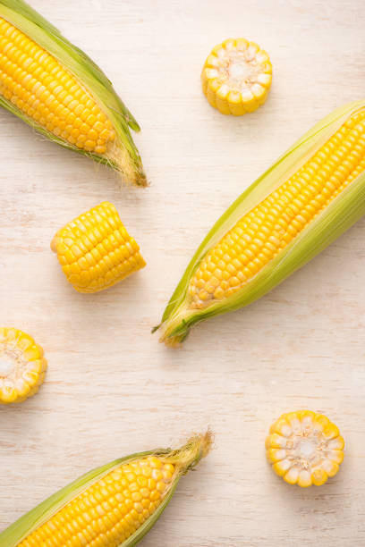 istock Sweet corns. Fresh corn on cobs on wooden table. 868451526