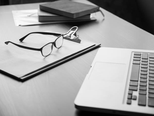 istock Office desk with laptop, glasses, documents and book. Black and White tone 868453868