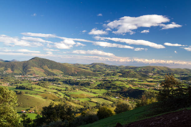 A beautiful day for this amazing view across the Pyrenees Mountain Ranges Blue skies, green grass and perfect conditions for the first day of the Camino Santiago in France heading over the border into Span saint jean pied de port stock pictures, royalty-free photos & images