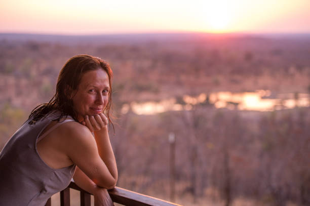 istock Side view of woman overlooking waterhole at sunset 868454726
