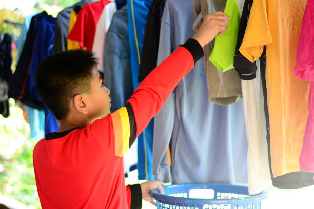 istock the  asian boy doing housework by hanging clothes with clothbar 868465800