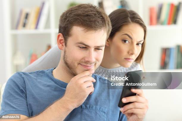 Man Dating On Line And Girlfriend Spying Stock Photo - Download Image Now - Infidelity, Couple - Relationship, Mobile Phone