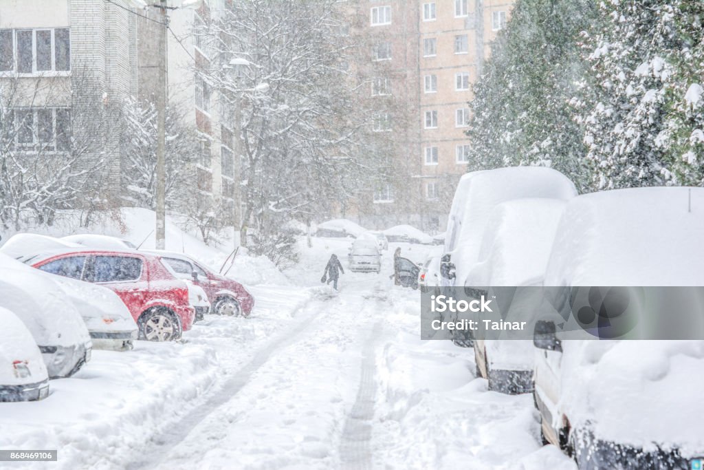 Snow-covered street/ Snowstorm Snow-covered street and cars with a lonely pedestrian. Heavy snowstorm Blizzard Stock Photo