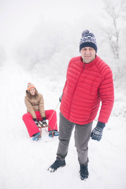 junges paar, rodeln und wintertag genießen - pair couple cheerful laughing stock-fotos und bilder