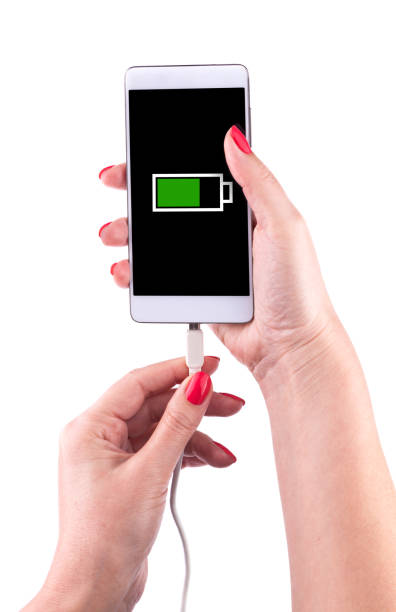 istock Female hand holding a smartphone and connecting charger 868469802