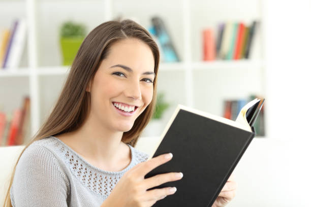 istock Girl reading a book and looking at camera 868470570