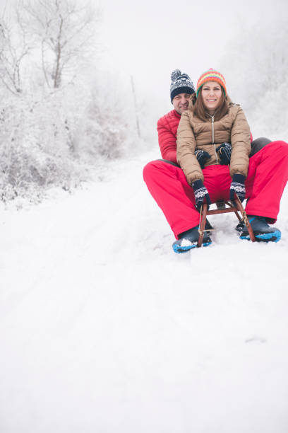 junges paar, rodeln und wintertag genießen - pair couple cheerful laughing stock-fotos und bilder