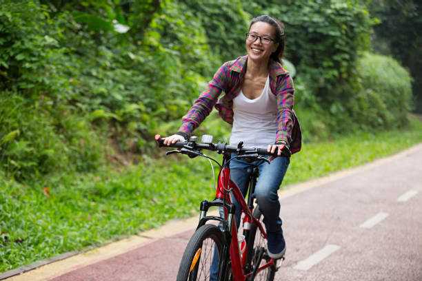 istock cheerful young woman cyclist cycling on forest trail 868478064
