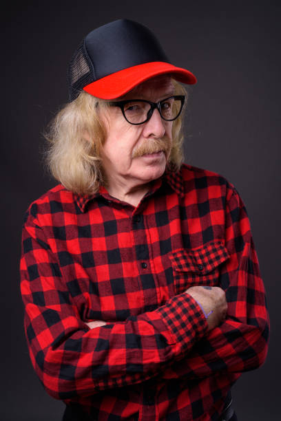 istock Senior man wearing red checked shirt against gray background 868478322