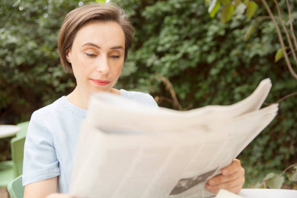 istock Businesswoman reading newspaper 868478450