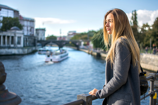 Young woman enjoying beautiful view at river Spree in Berlin.