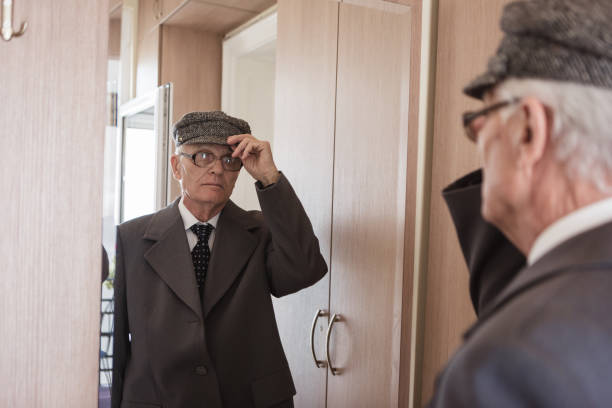 istock Seniors at Home. Senior man looking himself at the mirror, getting dresses 868484340
