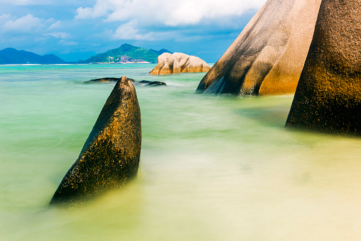 Sunset Beach, Mahe island, Seychelles. Coastal landscape with wet rock and ocean water on a clooudy summer day