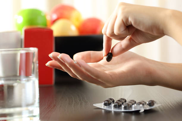 istock Woman hand catching a vitamin complex pill 868491082