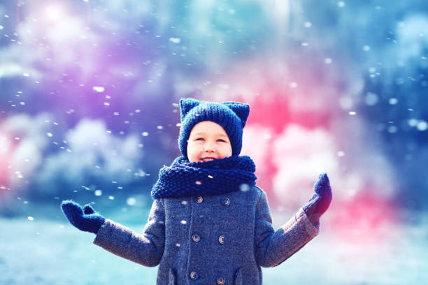 cute happy kid under the snow in winter park