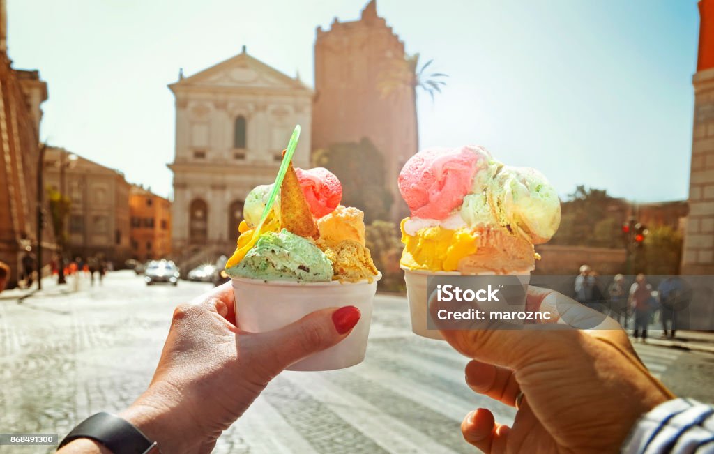 Couple with beautiful bright  sweet Italian ice-cream with different flavors  in the hands Couple with beautiful bright  sweet Italian ice-cream with different flavors  in the hands   on the square in Rome , Italy Ice Cream Stock Photo