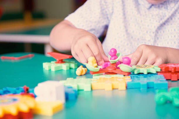 istock Little boy's hands playing with colorful plastic bricks at the table. Kids having fun and building out of bright constructor bricks. Early learning. Developing toys 868491916