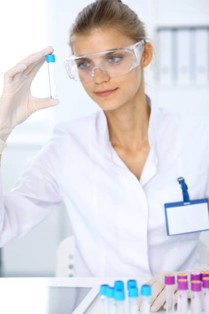 female scientific researcher in laboratory studying substances or blood sample. medicine and science concept - close up medical test exam people imagens e fotografias de stock