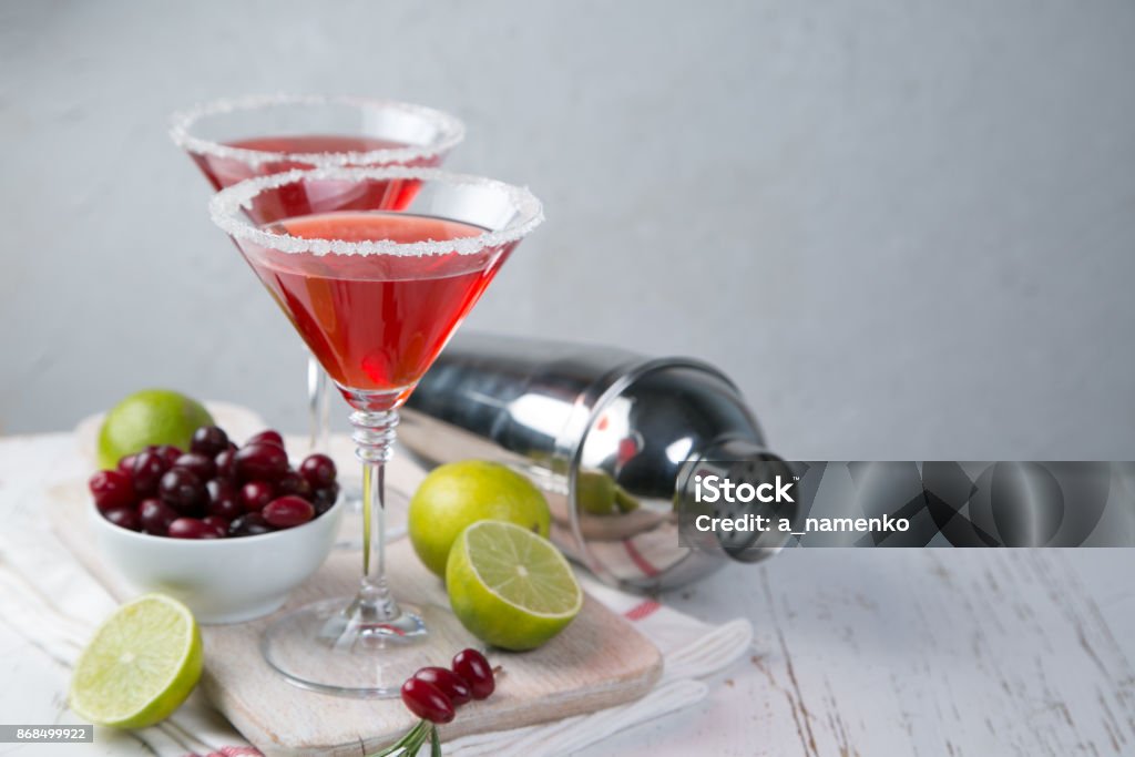 Cranberry and lime martini Cranberry martini in glasses on rustic background Cosmopolitan Cocktail Stock Photo