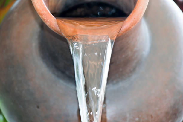 close up pour water out of terracotta pots. - pouring imagens e fotografias de stock