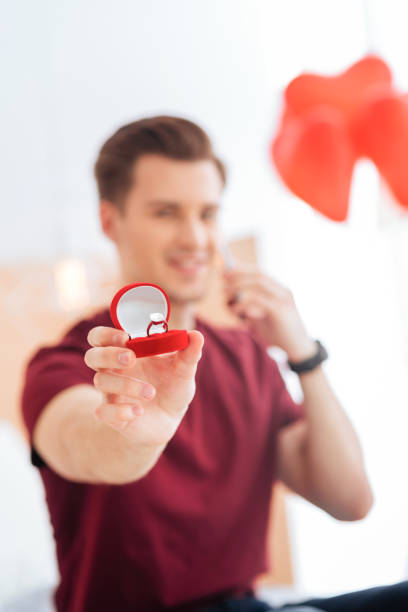istock Excited gentleman showing red velvet box with proposal ring 868507644