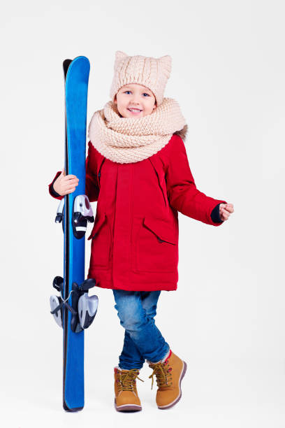 portrait of cute happy boy holding skis in hands portrait of cute happy boy holding skis in hands coat jacket winter isolated stock pictures, royalty-free photos & images