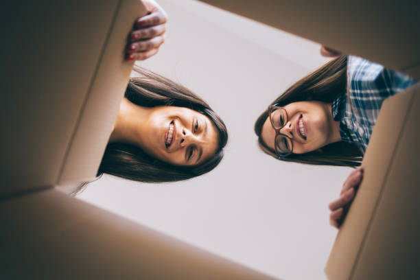 istock Pretty girls opens cardboard box 868515634