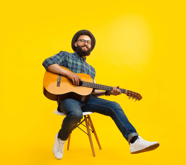 istock Stylish hipster playing guitar in studio 868515926