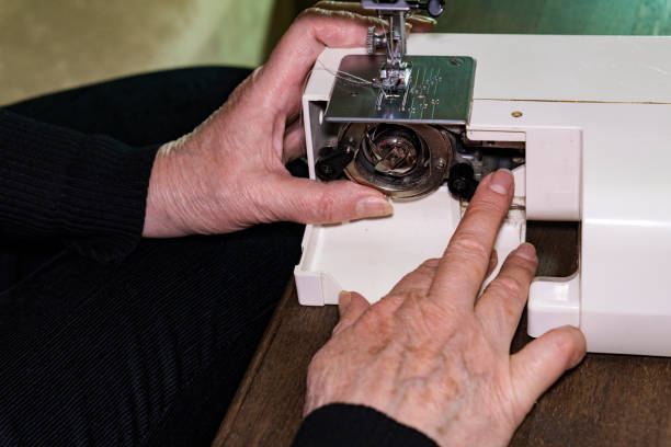 istock The woman's hands are replacing the spool of thread in the sewing machine. 868516128
