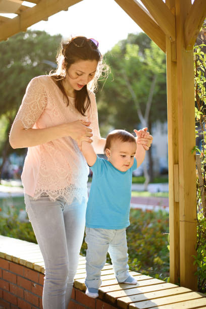 istock Mother teaching baby to walk 868523220