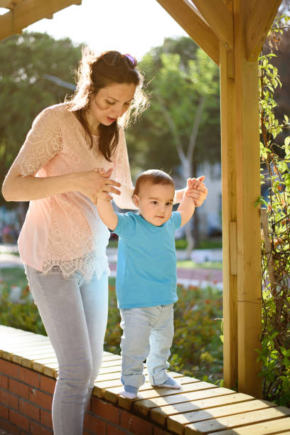 istock Mother teaching baby to walk 868523302
