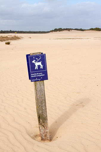 Signpost indicating dogs need to be leashed in this protected area