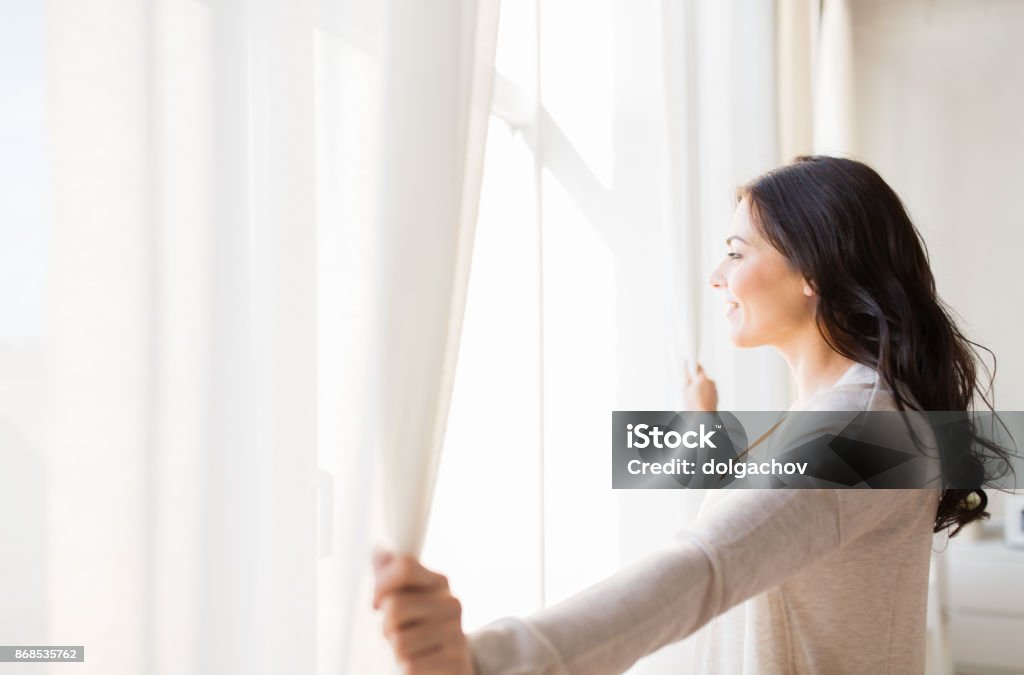 close up of woman opening window curtains people and hope concept - close up of happy woman opening window curtains Window Stock Photo