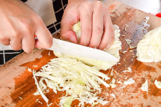 istock Chef sliing cabbage on wooden broad 868540960
