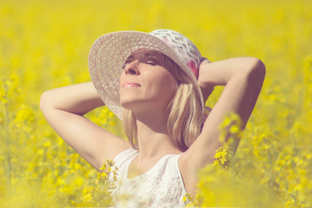 istock Young woman with a hat enjoying summer on the rape field. 868549454