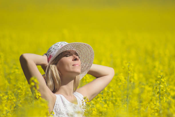 istock Young woman with a hat enjoying summer on the rape field. 868555288