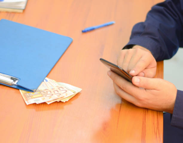 istock Man counting paper bills with a calculator on mobile phone. 868555434