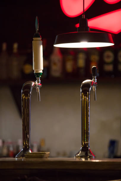 istock two beer cranes on bar counter on background wall with bottles 868557106