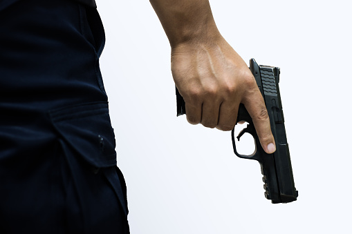 Man holding a gun in his hand with white background.