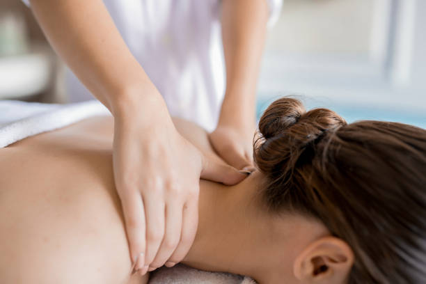 Work of masseur Hands of masseuse massaging neck and shoulders of relaxed client in spa salon massaging stock pictures, royalty-free photos & images