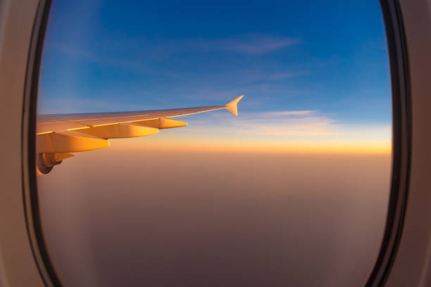 istock wing of airplane with morning sunrise through window 868569340