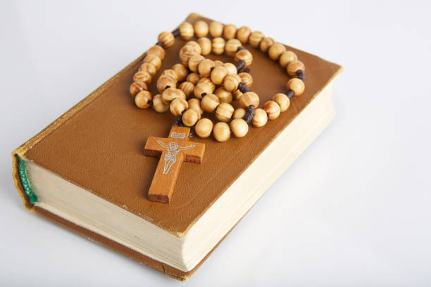 istock Bible and wooden rosary on a white background. 868575318