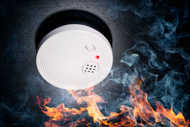 Smoke detector sounds the alarm in the event of a fire Smoke detectors with flames and smoke smoke detector photos stock pictures, royalty-free photos & images