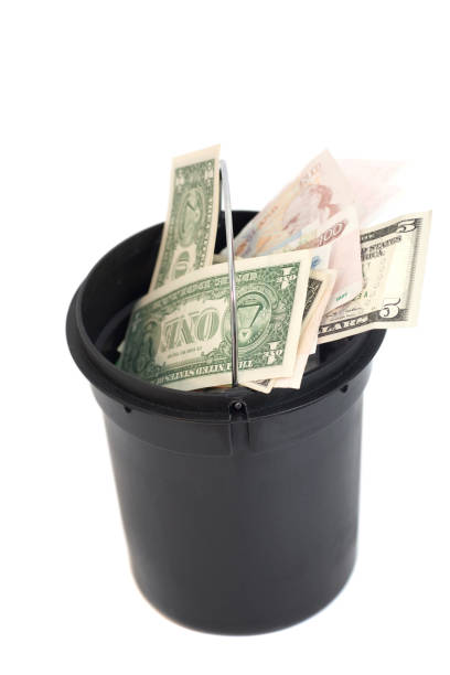 istock bucket with money over white background 868576432